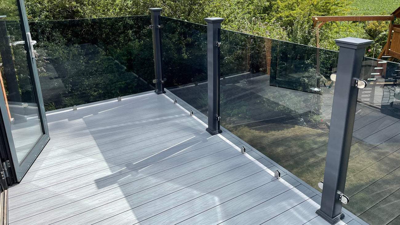 A glass balustrade surrounding a plastic decking