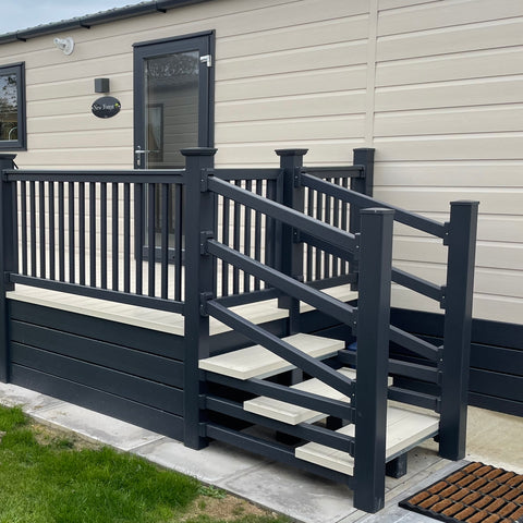 A fully installed 24' x 8' side patio decking kit with steps and a gate in the cream and anthracite