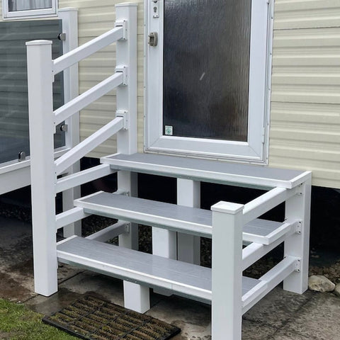 A set of white UPVC steps with a handrail, installed outside a door.